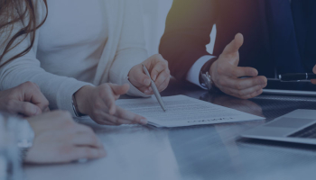 Drie personen die een contract aan het discuseren zijn
