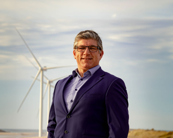 Een man met windmolens op de achtergrond