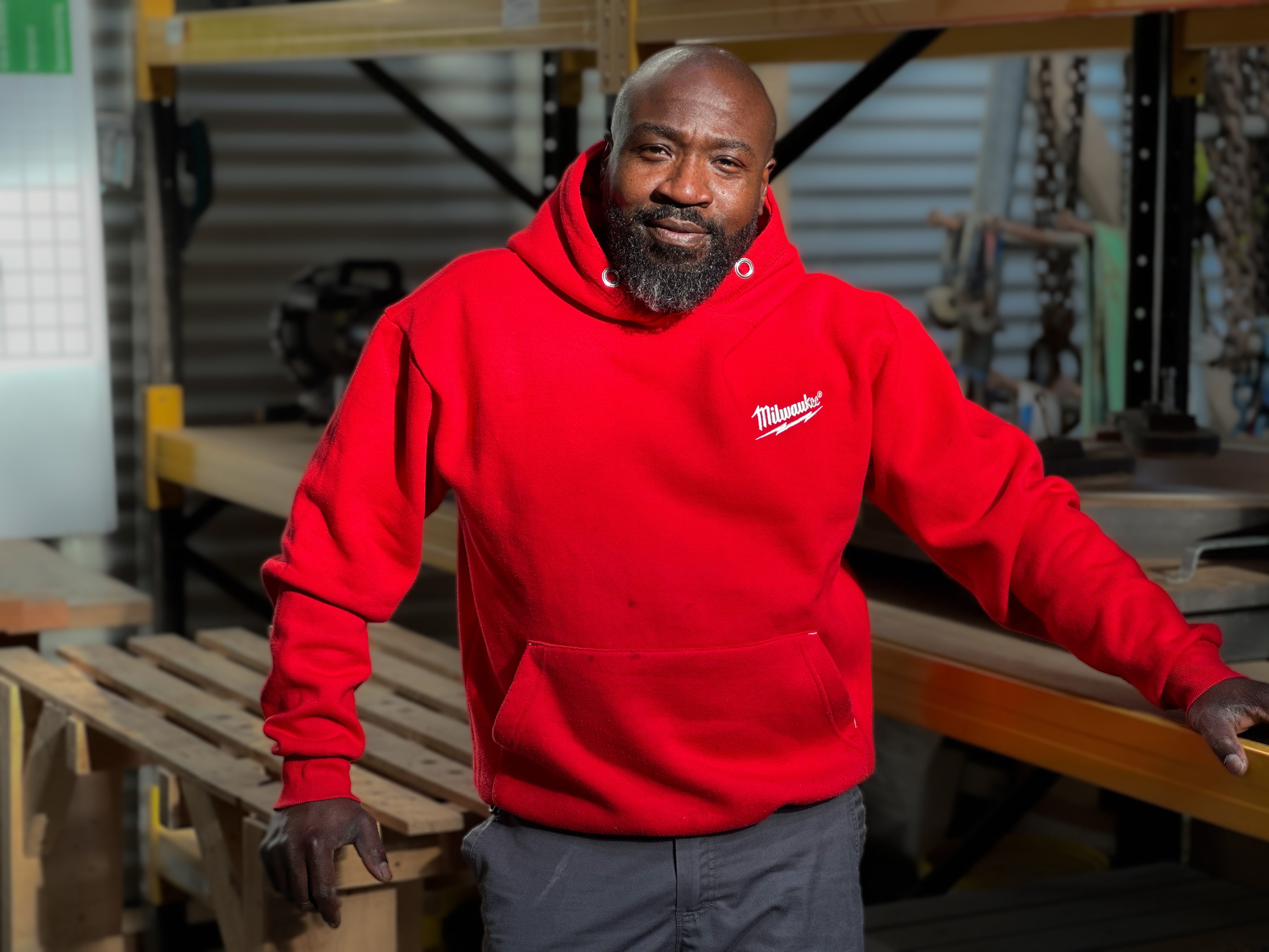 Een man met een rode trui staat op een bouwplaats
